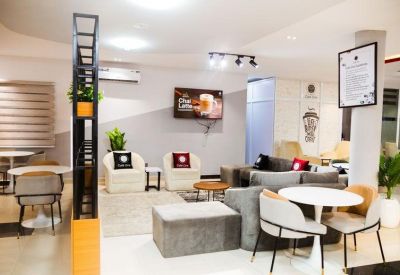 Modern lounge area with plush armchairs, grey sofas, and a white round coffee table.