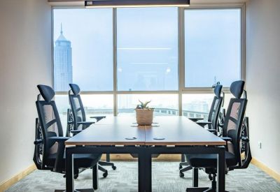 Professional meeting room with a large wooden table, mesh chairs, and floor-to-century city views.