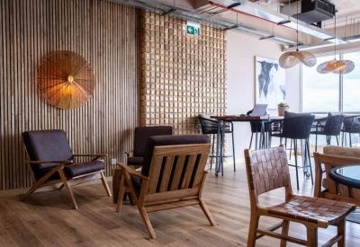 Lounge area at Mercure Nairobi Upper Hill with mid-century modern armchairs and a slatted wood feature wall.