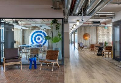 Spacious communal area featuring a blue target mural, wooden floors, and a variety of seating options.