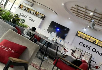 Lounge area featuring red armchairs, a patterned rug, and branded wall signage.