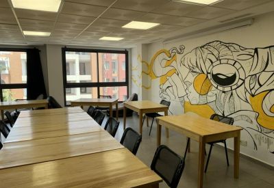 Large meeting space with multiple wooden tables and a black and yellow feature wall mural.