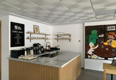Bright communal kitchen area featuring a wood-panelled counter and colorful cartoon wall art.
