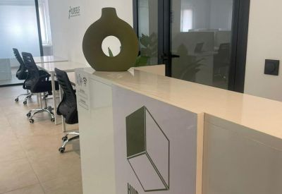 White reception desk with a modern green circular vase and branded Hub Station signage.