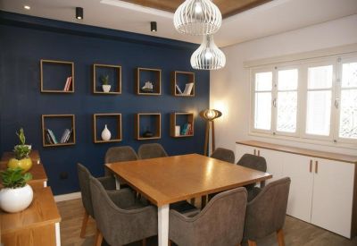 Warm meeting room with a wooden table, grey chairs, and decorative wall shelving.