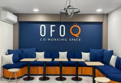 Lounge area with blue tiered seating and orange accents at Ofoq Co-Working Space, 965 Omar Ibn El-Khattab St.