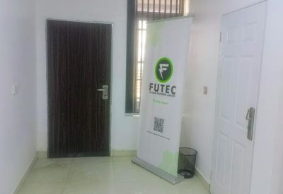 Reception or waiting area with a branded banner stand and a white door.