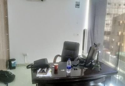 Private office featuring a dark wood desk, leather executive chair, and monitor.