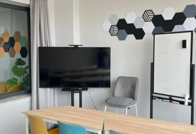 Meeting room with a large screen, whiteboard, and colorful seating.