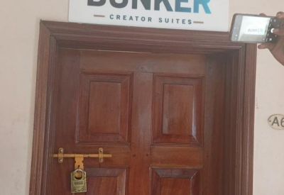 Wooden entrance door with a branded sign above indicating the entrance to the creator suites.