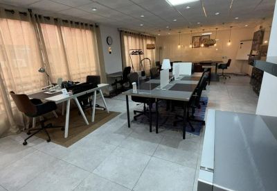 Open-plan workspace with long shared tables and individual task lighting.