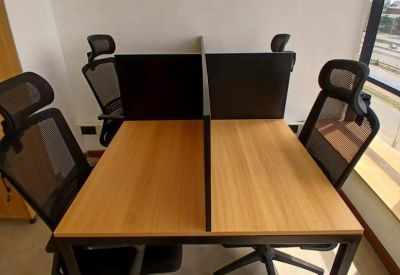 Office space with four ergonomic chairs and two shared desks.