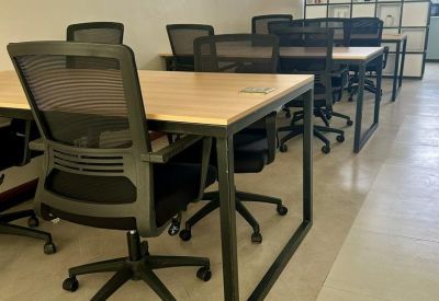 Open-plan workspace with desks and ergonomic chairs.