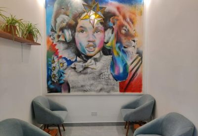 Lobby seating area featuring blue armchairs and a vibrant mural of a child's face.