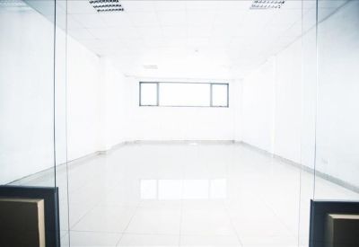 Symmetrical view of a vacant, brightly lit internal office space seen through glass doors.