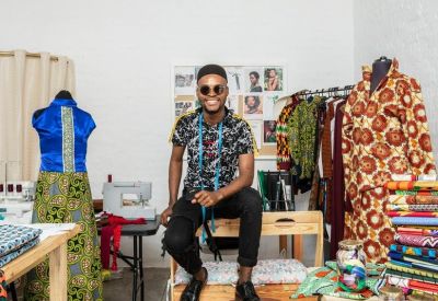 Bright fashion design studio with mannequins and workstations.