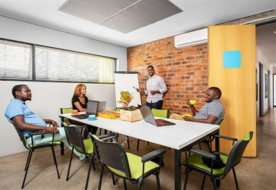 Modern meeting room with brick feature wall and white conference table.