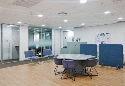 Modern coworking space with a pentagon-shaped table and blue privacy screens.