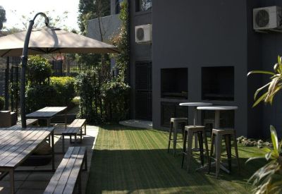 Outdoor breakout area with wooden picnic benches and artificial lawn.