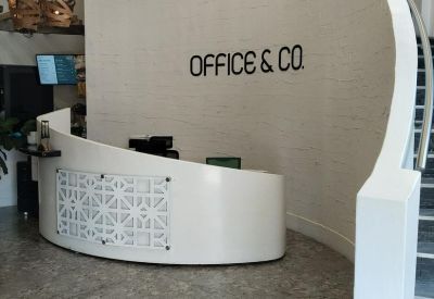Curved white reception desk and feature wall with Office & Co branding.