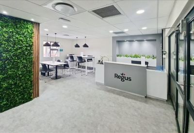 Reception area featuring a branded desk and a vibrant green moss feature wall.