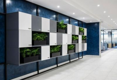 Modular locker storage unit in white and grey with built-in planters on a blue feature wall.