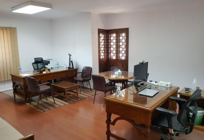 Two-desk wooden office suite with natural light and a round glass meeting table.
