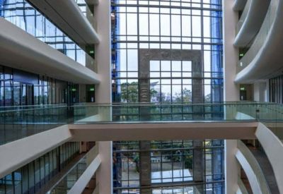 Spacious multi-story atrium with indoor plants and bridges connecting upper levels.