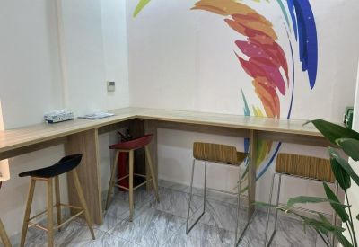 Breakout area with a wooden L-shaped counter, colorful wall mural, and bar stools.
