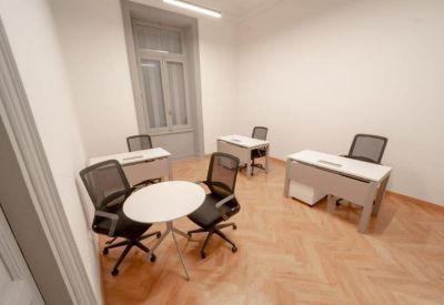 Private office space featuring three grey desks and black mesh ergonomic chairs.