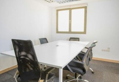 Bright conference room with a white table and modern light fixtures.