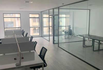 Workspace with glass-walled private office and conference table.