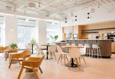 Communal kitchen and dining area with light wood cabinetry and high-top seating.