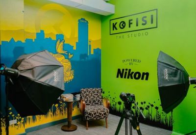Vibrant media studio with professional lighting, a Nikon-branded wall, and colorful cityscape mural.