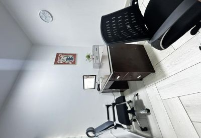 Private office featuring a dark wood desk, ergonomic chair, and abstract wall art.