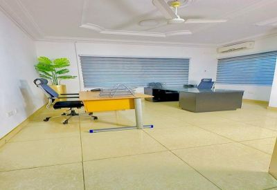 Wide view of a bright professional office with tiled flooring and blue window blinds.