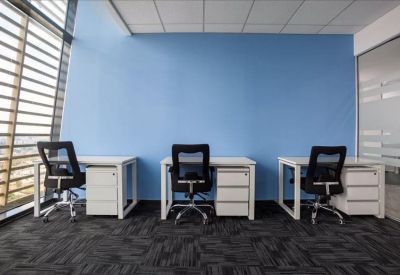 Bright three-person office suite with a blue accent wall and large windows.
