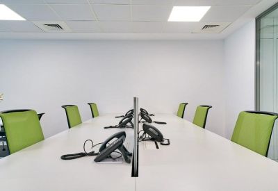 Office workspace with white desks, privacy dividers, and lime green chairs.