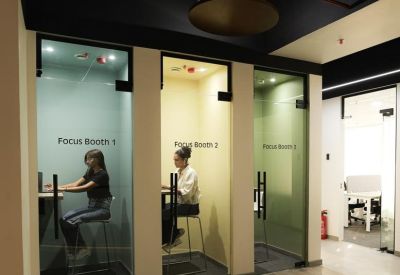 Modern breakout area with three private, color-coded phone booths.
