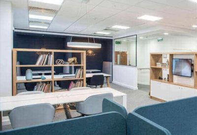 Cozy communal area with bookshelves and a lounge chair.