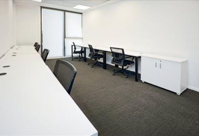 Bright private office featuring white workstations and black ergonomic chairs.