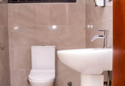 Modern bathroom with a white pedestal sink and neutral tiling.