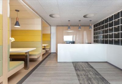 Bright reception area with white desk and cozy booth seating.