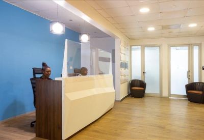 Modern reception area with a blue feature wall and a geometric white front desk.