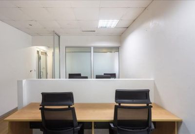 Bright workspace featuring white desks and frosted glass partitions.