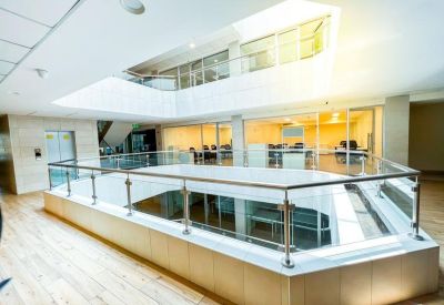 Multi-level interior balcony overlooking a glass-walled office area.