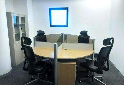 Internal four-person office suite with curved wooden desks and black ergonomic chairs.