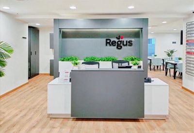 Professional reception desk with the Regus logo and indoor plants.