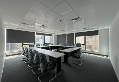 U-shaped conference room with black ergonomic chairs and grey roller blinds.
