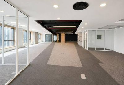 Modern corridor view showing glass meeting rooms and integrated ceiling lighting.